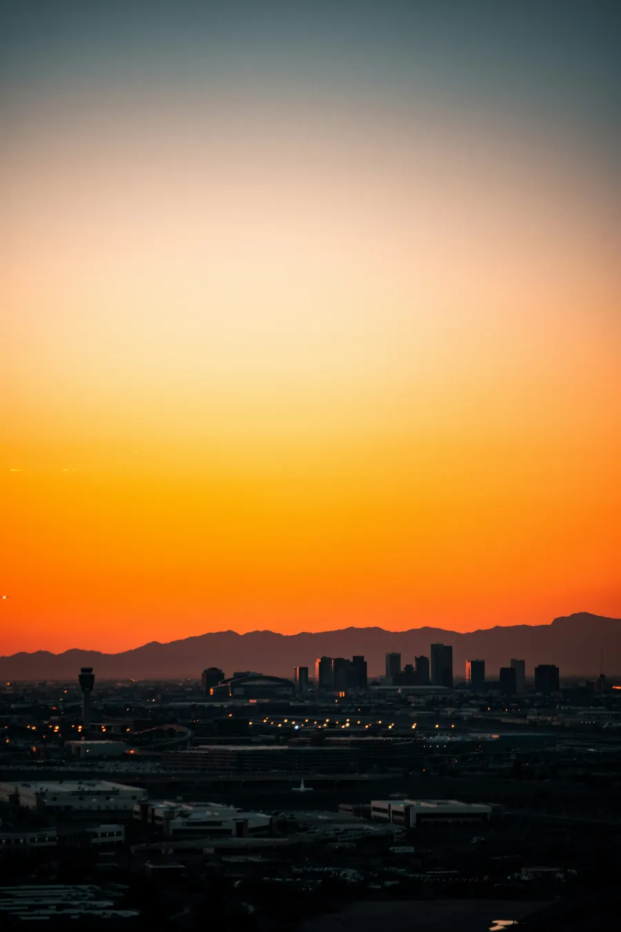Phoenix skyline at sunset with mountains and city lights